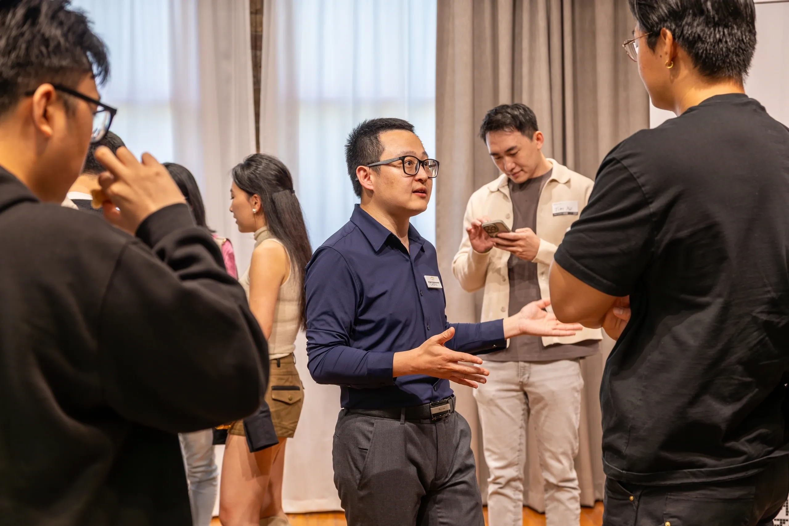 People networking and conversing at an indoor event.