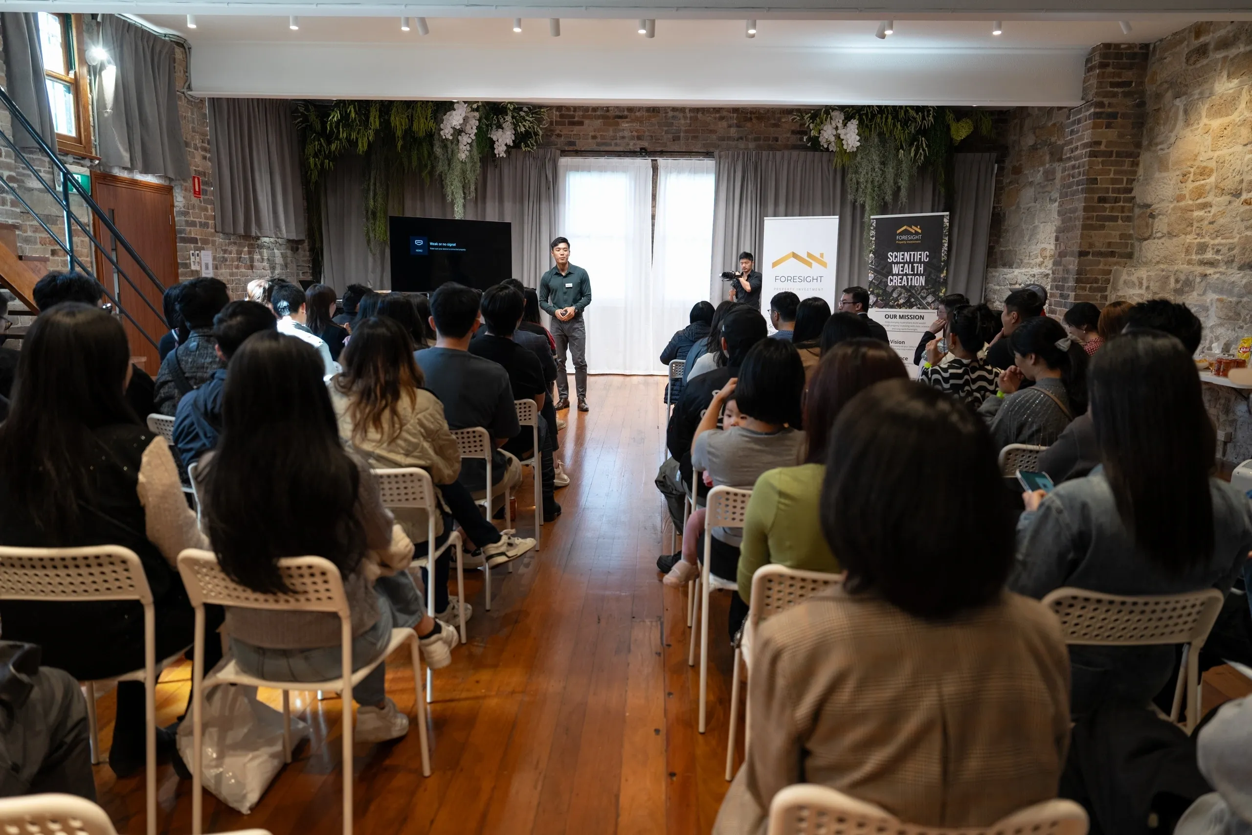 Speaker addressing an attentive audience in a cozy indoor setting.