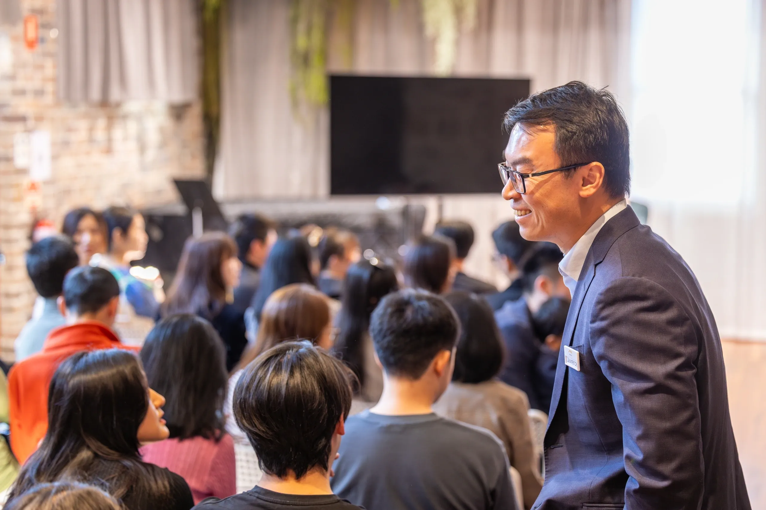 A man speaking to a seated audience in a conference.